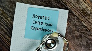 Adverse Childhood Experiences note with stethoscope on wooden desk