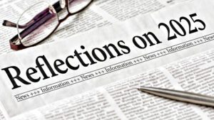 Newspaper headlined 'Reflections on 2025' with glasses and pen on newsprint